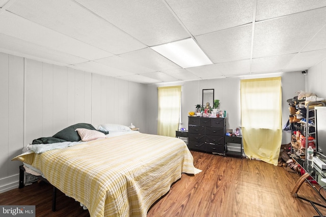 bedroom featuring a paneled ceiling and wood-type flooring