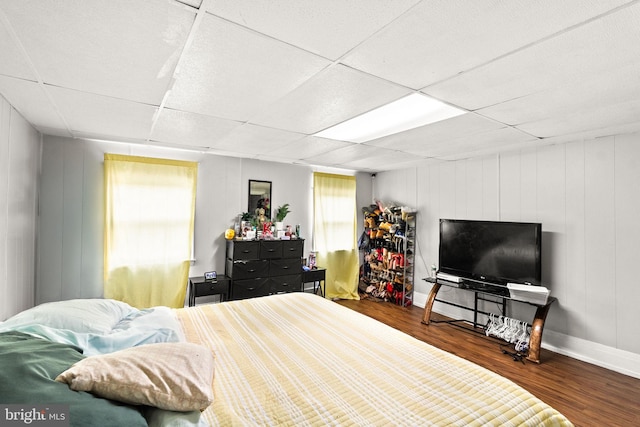 bedroom featuring hardwood / wood-style flooring and a drop ceiling