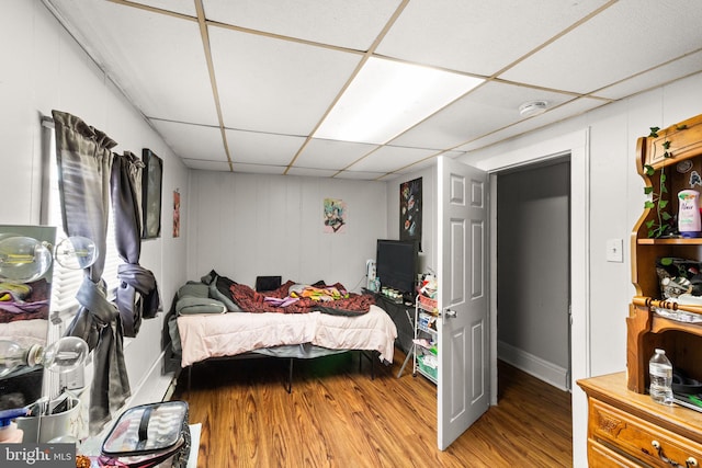 bedroom with a drop ceiling and hardwood / wood-style flooring