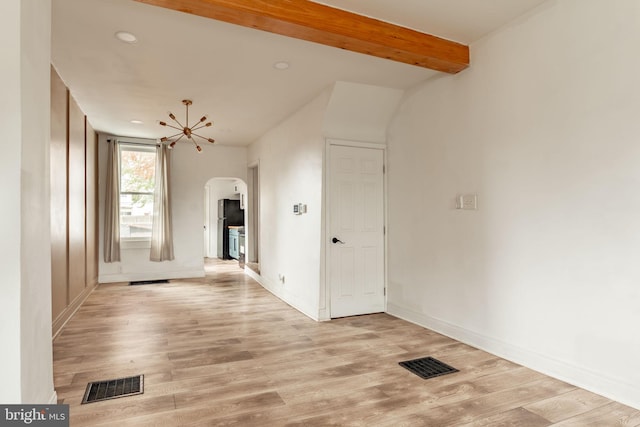 unfurnished room featuring beam ceiling, light hardwood / wood-style floors, and a notable chandelier