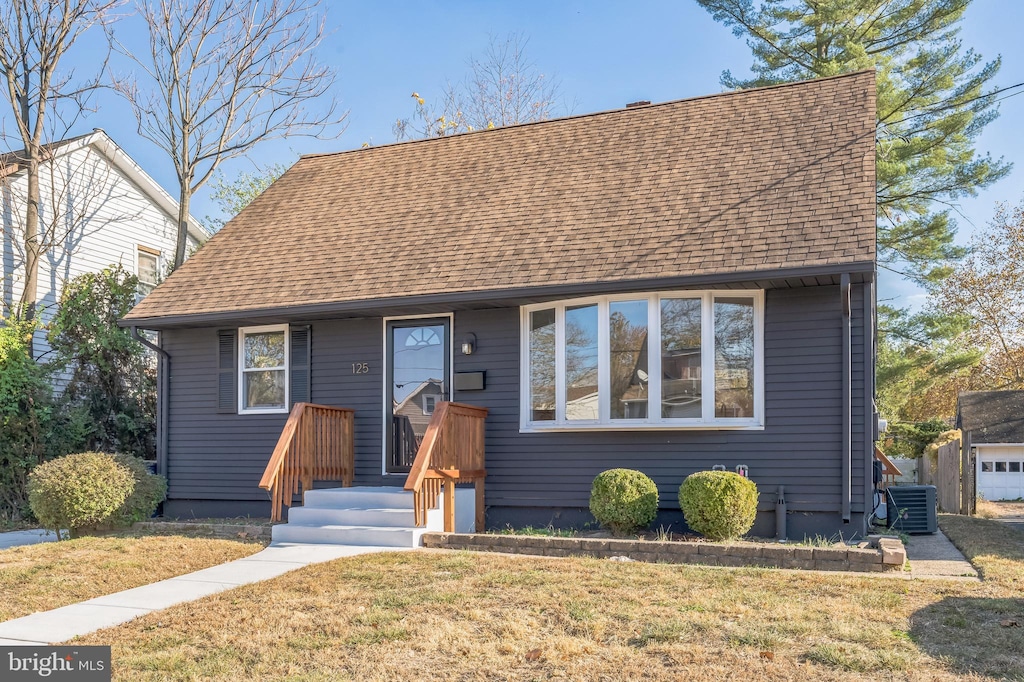 view of front facade featuring a front lawn and cooling unit