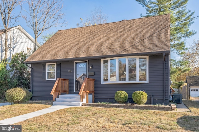 view of front facade featuring a front lawn and cooling unit