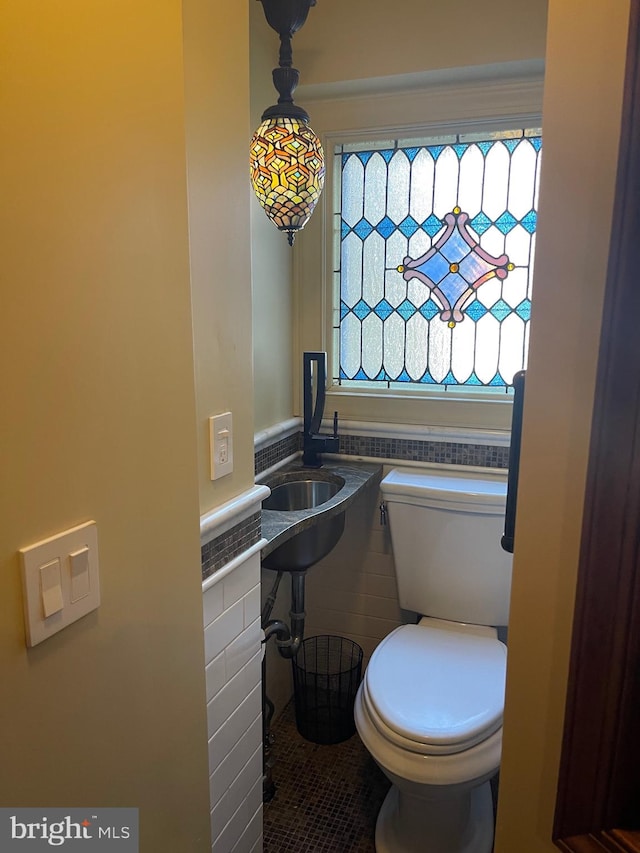 bathroom with tile patterned flooring, toilet, and tile walls