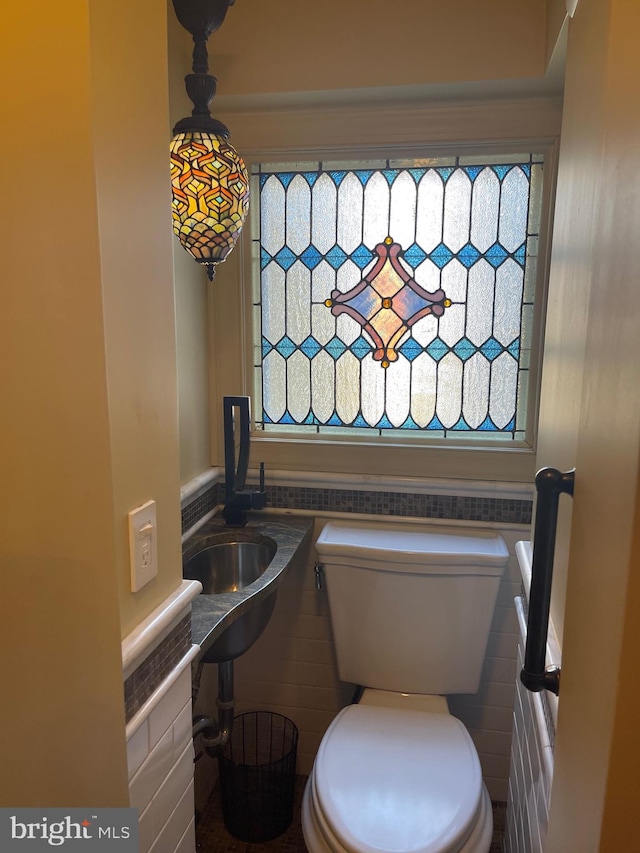 bathroom featuring a wealth of natural light, tile walls, and toilet