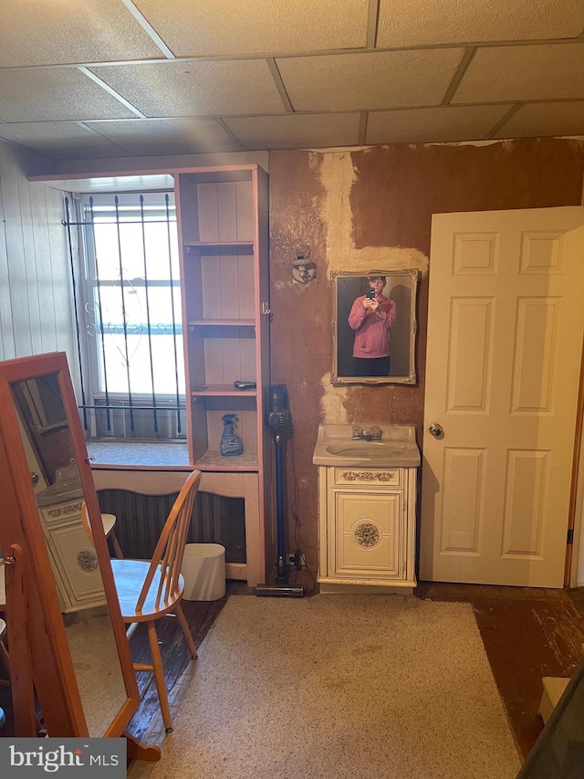 carpeted home office featuring a paneled ceiling and sink