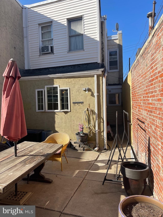 back of property featuring cooling unit and a patio area