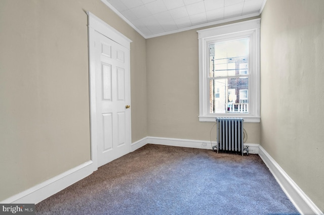 carpeted spare room with radiator and crown molding