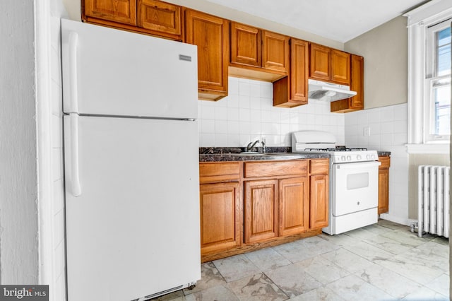 kitchen featuring radiator, backsplash, white appliances, and sink