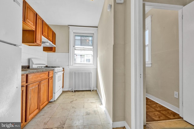 kitchen with radiator heating unit and white appliances