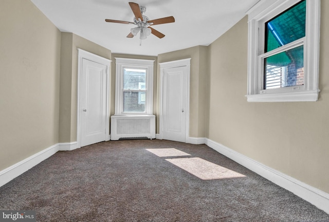 unfurnished bedroom featuring radiator, carpet, and ceiling fan