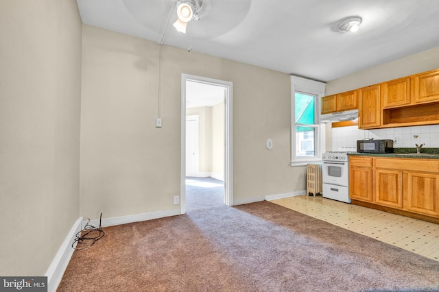 kitchen with sink, light carpet, white range with gas stovetop, and tasteful backsplash