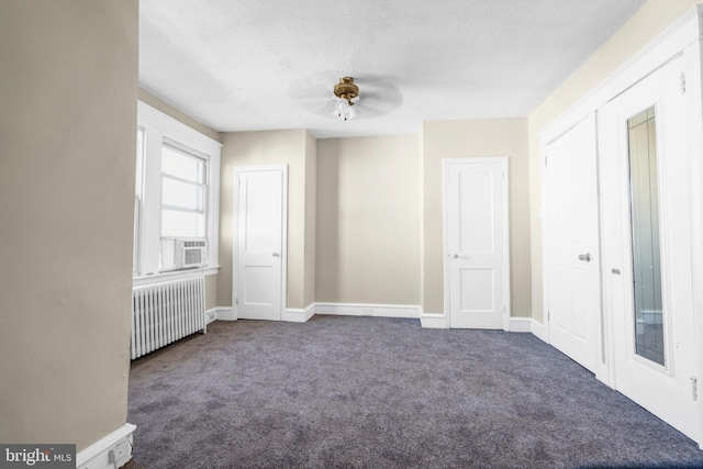 carpeted spare room with radiator, a textured ceiling, and ceiling fan