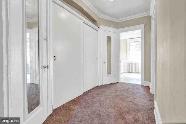 interior space with carpet flooring, radiator heating unit, and ornamental molding