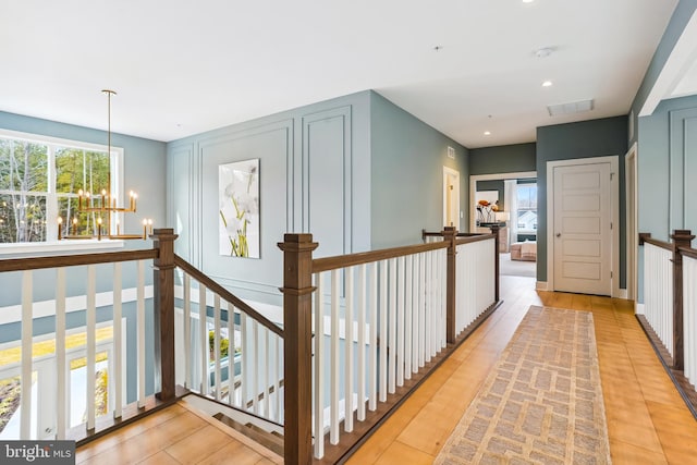 hallway with light tile patterned floors and a notable chandelier