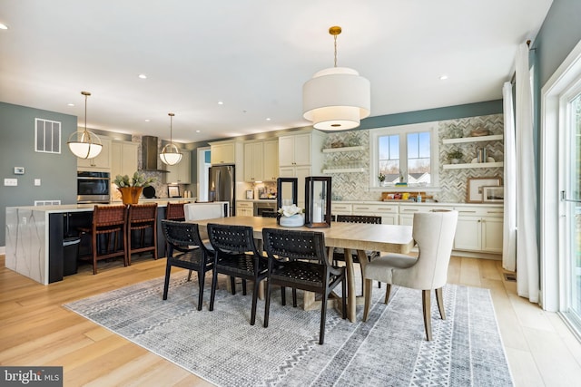 dining space with a healthy amount of sunlight and light hardwood / wood-style flooring