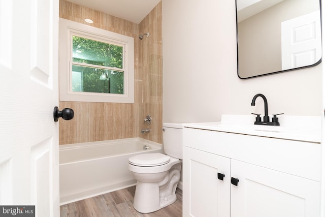 full bathroom with wood-type flooring, vanity, toilet, and tiled shower / bath combo