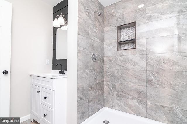 bathroom with vanity and a tile shower