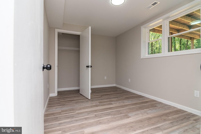 unfurnished bedroom with light hardwood / wood-style floors and a closet