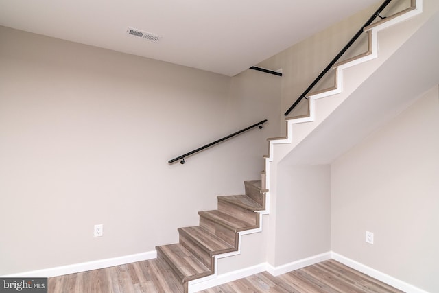 staircase with hardwood / wood-style flooring