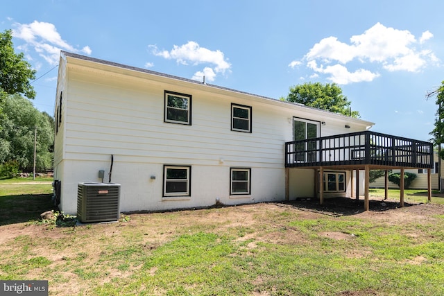 rear view of house featuring a wooden deck, a lawn, and cooling unit