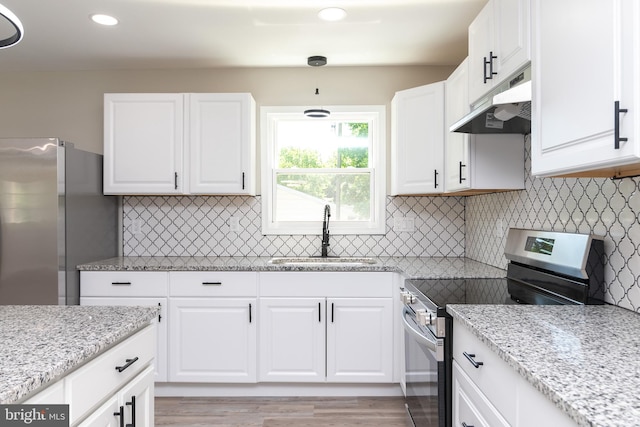 kitchen with white cabinets, light wood-type flooring, stainless steel appliances, and sink