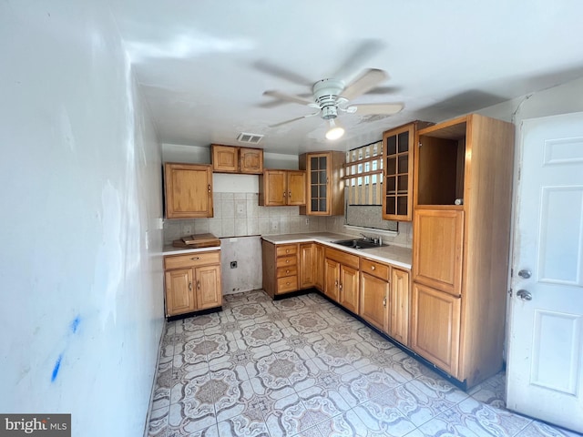 kitchen featuring tasteful backsplash, sink, and ceiling fan