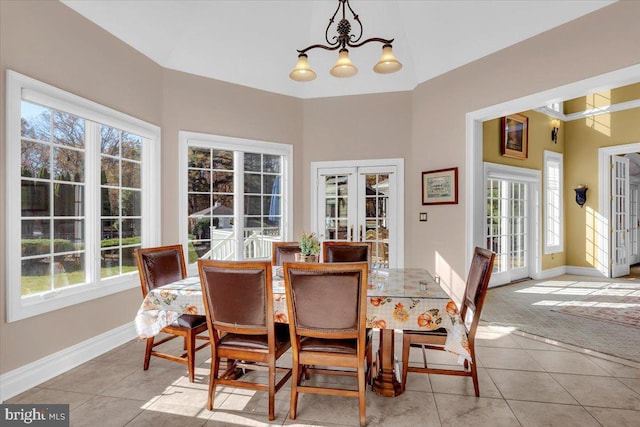 dining area with a wealth of natural light, a chandelier, and french doors