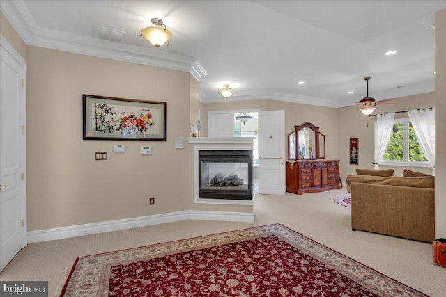 carpeted living room featuring a multi sided fireplace, ceiling fan, and crown molding