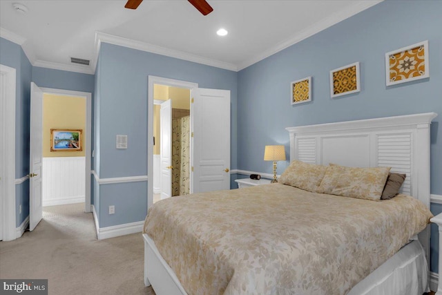 carpeted bedroom featuring ceiling fan, ornamental molding, and ensuite bath