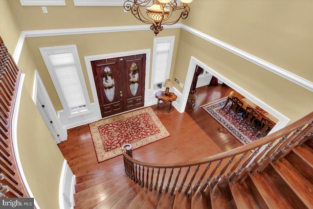 foyer entrance featuring a chandelier, hardwood / wood-style floors, and a towering ceiling