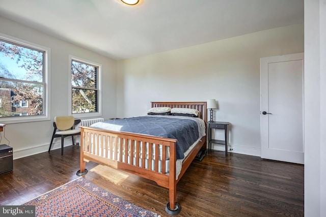 bedroom with dark hardwood / wood-style flooring