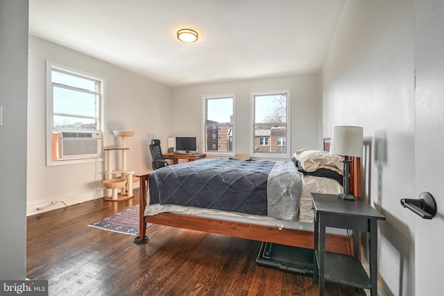 bedroom featuring wood-type flooring, multiple windows, and cooling unit