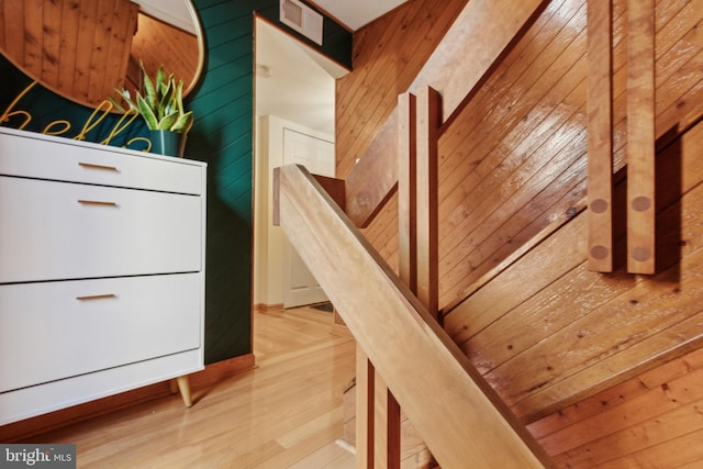 stairs featuring wood walls and wood-type flooring