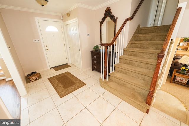 entrance foyer with tile patterned flooring and ornamental molding