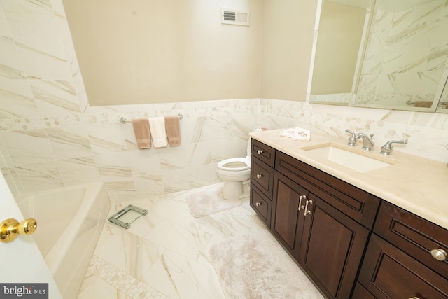 bathroom featuring tile walls, toilet, vanity, and a tub