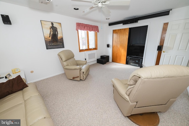 carpeted living room with a wall unit AC and ceiling fan