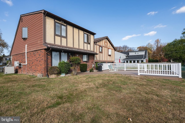 back of house with a lawn and a deck