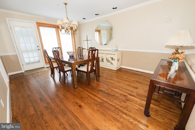 dining area featuring ornamental molding, wood-type flooring, and an inviting chandelier