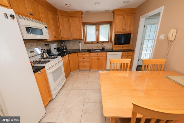 kitchen featuring sink, white appliances, decorative backsplash, and a healthy amount of sunlight