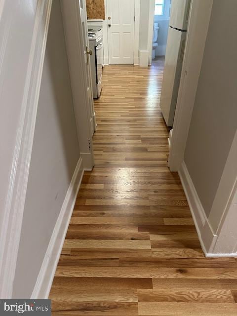 corridor with hardwood / wood-style flooring