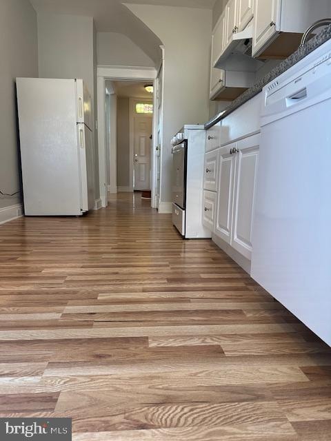 kitchen with white cabinets, white appliances, and light hardwood / wood-style flooring