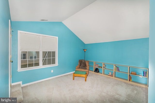 sitting room featuring carpet floors and lofted ceiling