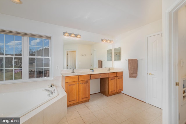 bathroom featuring tile patterned floors, tiled bath, and vanity