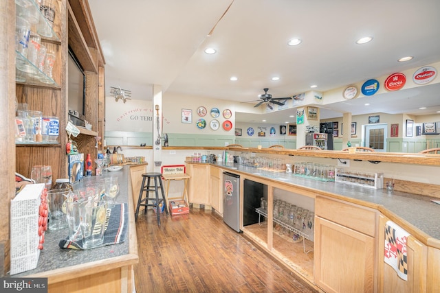 kitchen with hardwood / wood-style flooring, ceiling fan, light brown cabinetry, and fridge