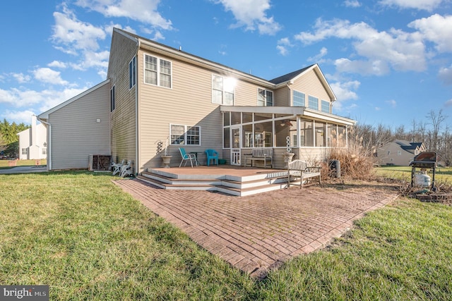 back of house featuring a sunroom, a deck, and a yard