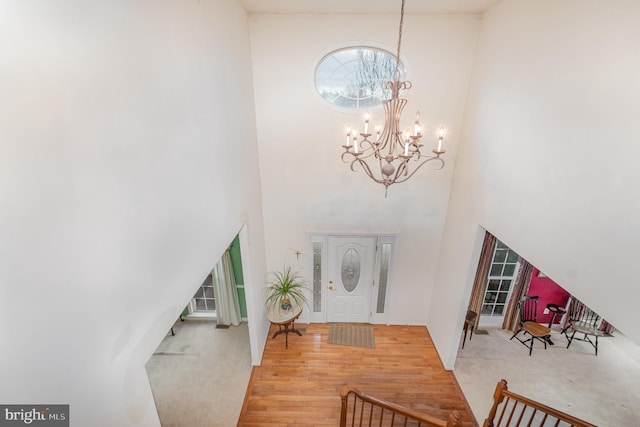 entrance foyer with hardwood / wood-style floors and a notable chandelier