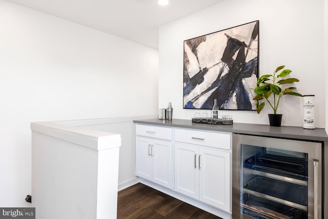 bar with dark hardwood / wood-style floors, beverage cooler, and white cabinetry