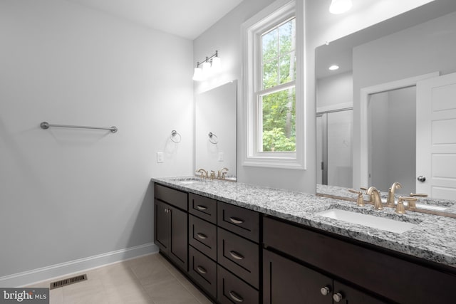 bathroom featuring vanity, a shower with door, and tile patterned flooring