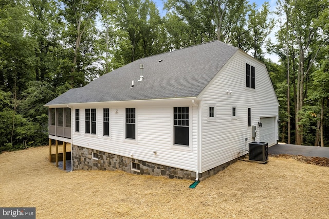 back of house featuring a garage and cooling unit