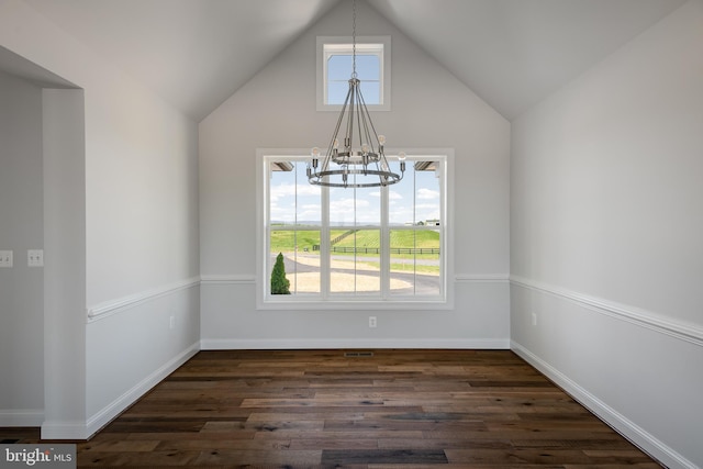 unfurnished dining area featuring dark hardwood / wood-style floors, an inviting chandelier, and vaulted ceiling